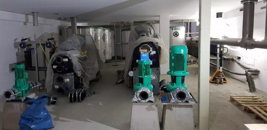 Teknisk rum i en ny byggnad där pumpar och en kompressor ska installeras – byggnadens klimatkontrollsystem.