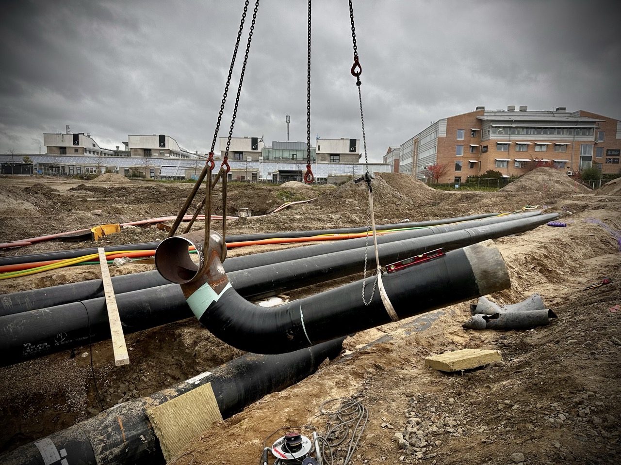 A DN 400 pipeline section suspended by a crane during the pipe fabrication process. The prefabricated pipe spool is being moved for installation or further welding.