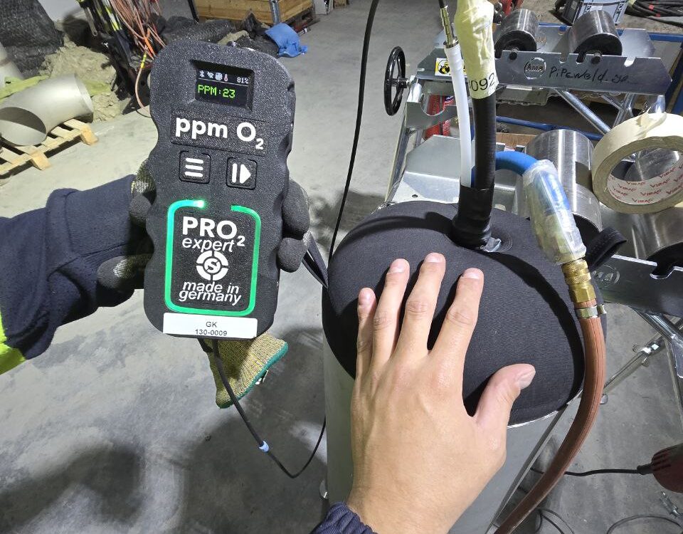 Mechanical contractor team testing gas analyzer for purge system during stainless steel piping welding in Oslo, Norway