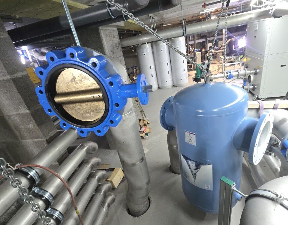 Mechanical contractor preparing installation of vortex water filtration system with stainless steel piping in Oslo, Norway