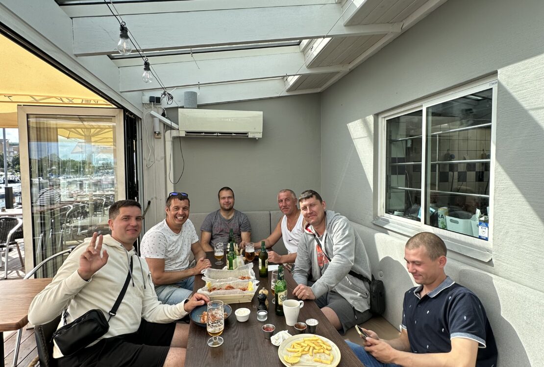 Piping installation team of welders having lunch at seaside restaurant during weekend